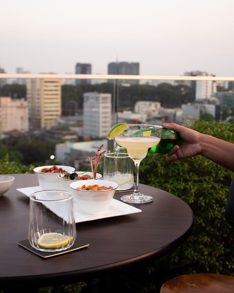 Margarita and snacks on a rooftop table above a city skyline