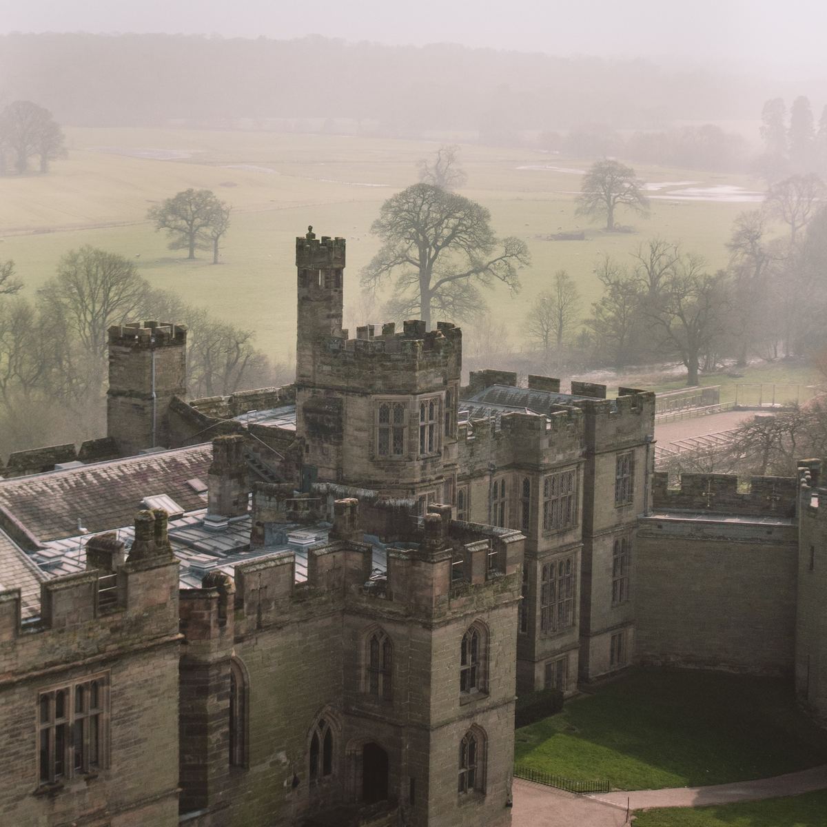 Warwick Castle towers above misty parkland
